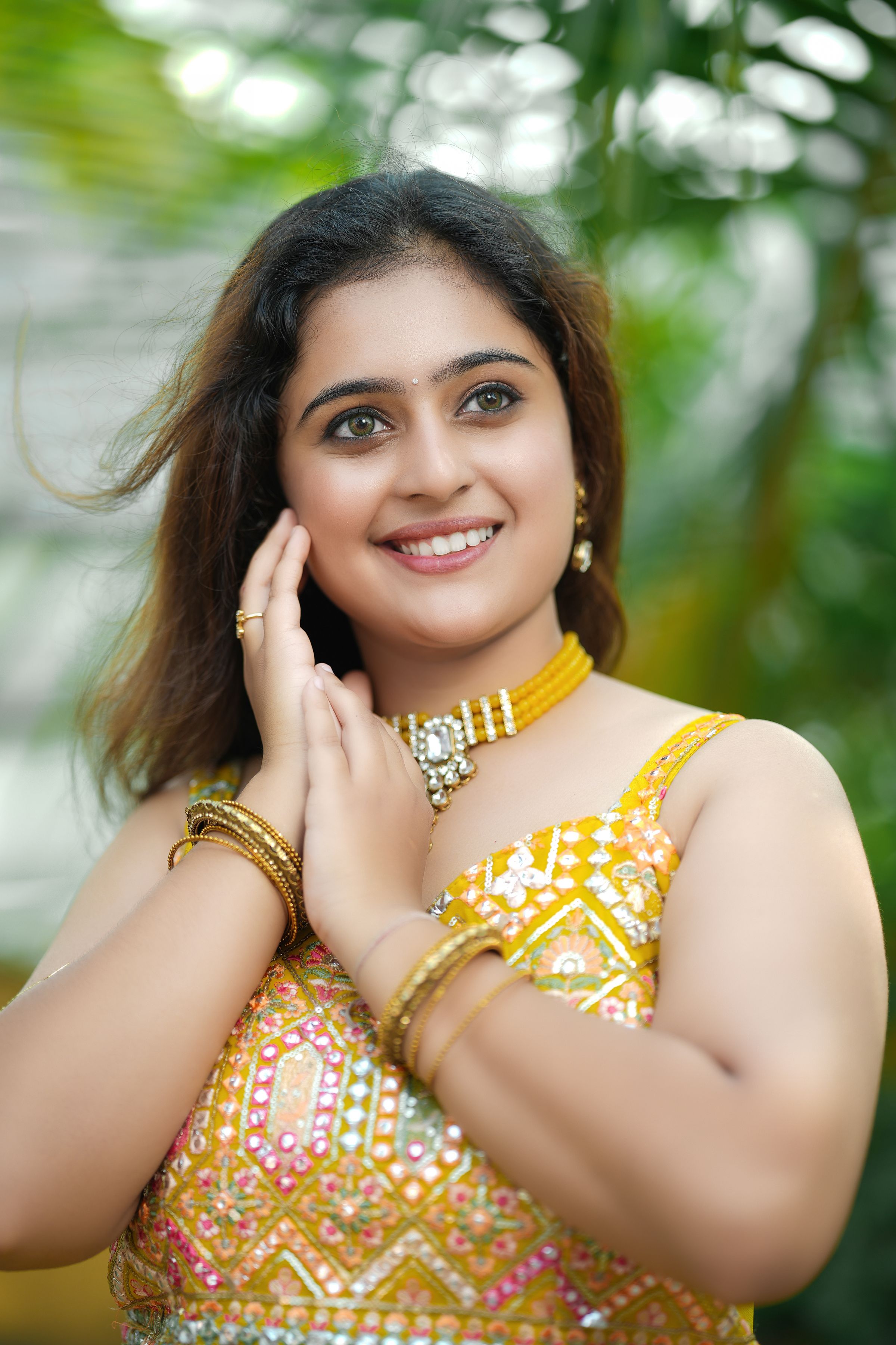 Model in a yellow editorial look wearing gold-toned fashion jewellery outdoors